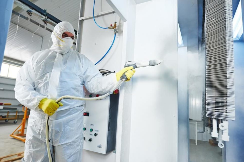 Ein Azubi im Schutzanzug bei der Metall-Beschichtung in der Oberflächenbeschichter Ausbildung
