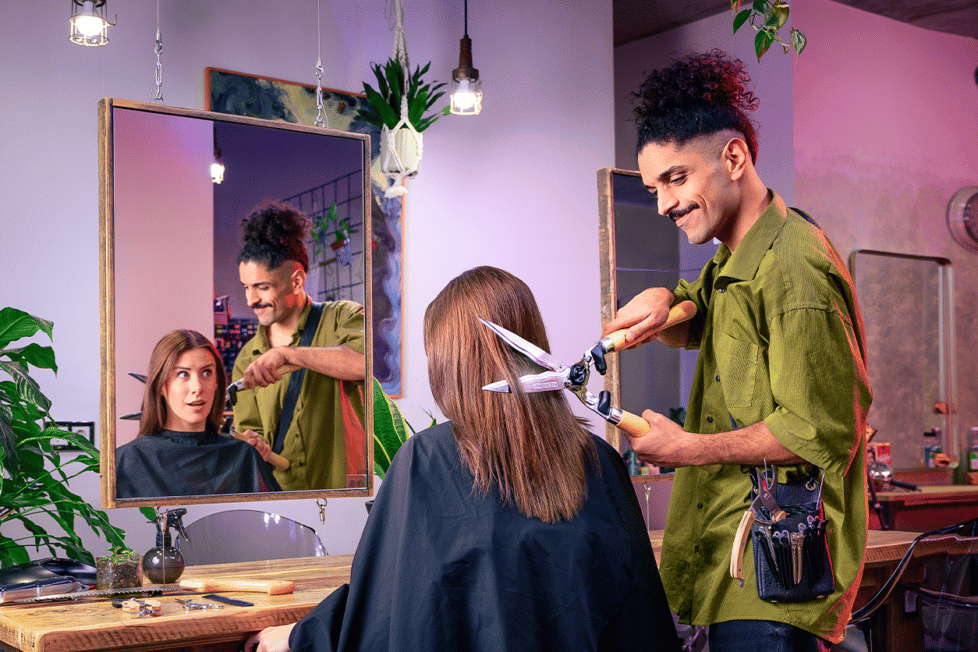 Friseur schneidet Kundin mit Heckenschere die Haare