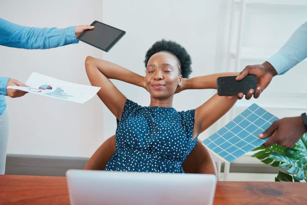 Arbeitnehmerin lehnt sich entspannt zurück, während ihr Arbeit vorgehalten wird - Quiet Quitting