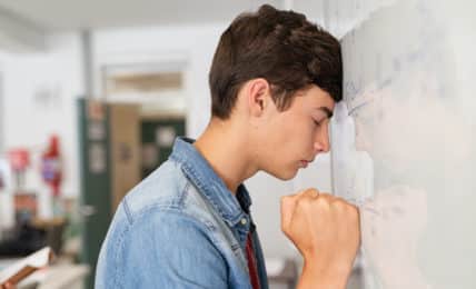 Junger Student an der Tafel hat Prüfungsangst