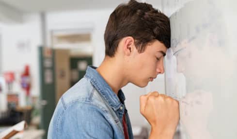 Junger Student an der Tafel hat Prüfungsangst