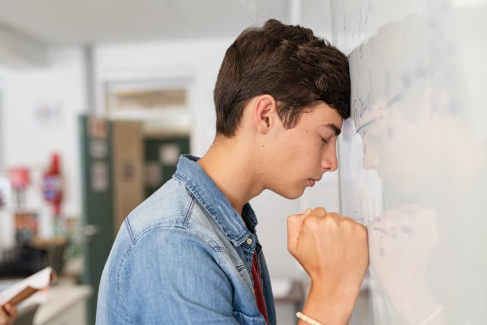 Junger Student an der Tafel hat Prüfungsangst