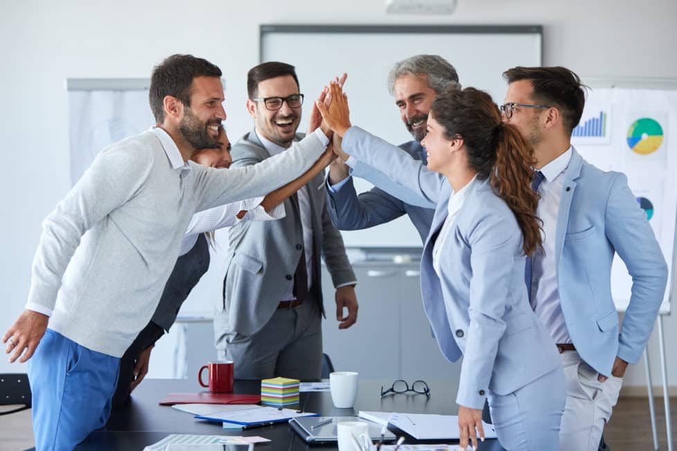 Team in Büro klatscht ab - Teamfähigkeit