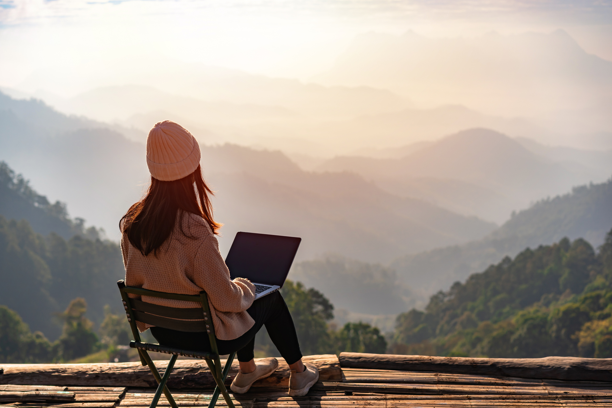Junge Frau arbeitet auf Terrasse am Laptop
