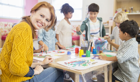 Teacher and students painting in classroom